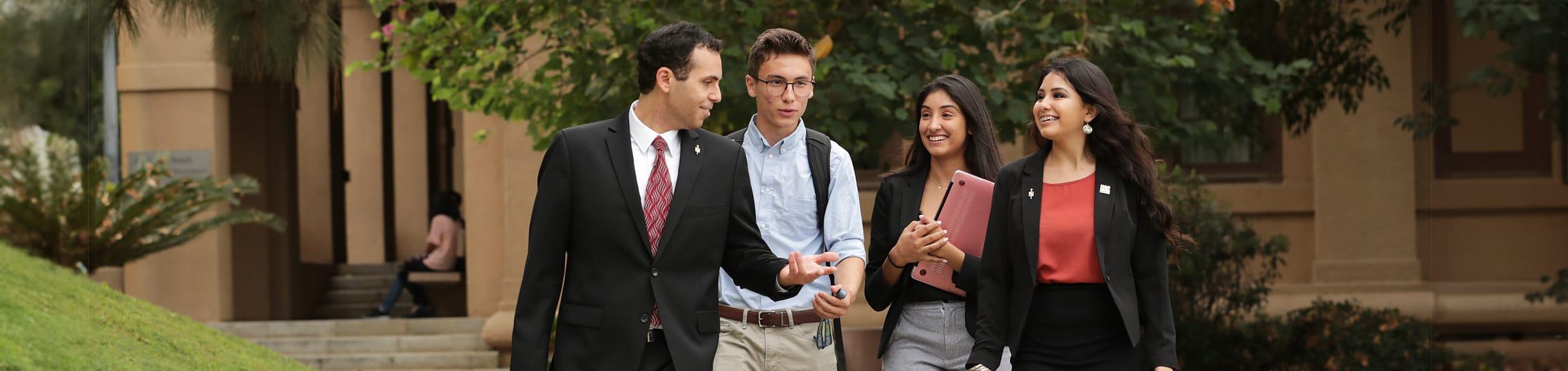 UCR school of business students walking and talking with a professor