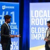Two UCR student ambassadors talk in front of Gala 2025 signage.